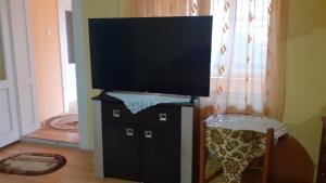 een flatscreen-tv op de top van een zwarte dressoir bij Alex Lux apartment in Glimboca