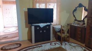 een woonkamer met een flatscreen-tv op een standaard bij Alex Lux apartment in Glimboca