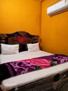 a bedroom with a large bed with a purple blanket at DIOMAND HOTEL AND RESTURENt in Bilgrām