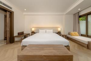 una camera da letto con un grande letto bianco e un tavolo di Bhu Nga Thani Resort & Villas Railay a Railay Beach Altre 91 foto