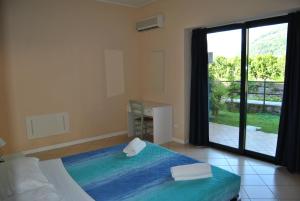 a bedroom with a bed and a large window at Residence Oasi Del Viandante in Dervio