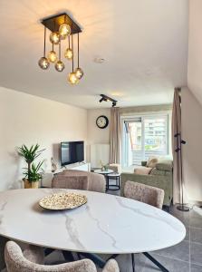 a living room with a white table and chairs at Cosy Corner 4 in Nieuwpoort +11 photos