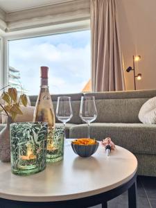 a bottle of wine and two wine glasses on a table at Cosy Corner 4 in Nieuwpoort