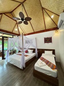 2 Betten in einem Zimmer mit einer Decke in der Unterkunft Coconut Minh Tho Homestay in Mai Châu