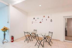 CimanggisにあるSPAZIE at Eden Guesthouse Depokの白い壁の客室内のテーブルと椅子