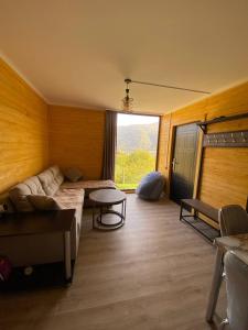 Una sala de estar con un sofá y una ventana grande. en Forest Panorama House Dilijan, en Dilijan
