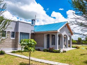 una casa con techo de estaño azul en Peaceful Getaway in Kajiado County - Riri Isinya, en Oloyaingalani