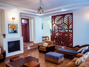 Una sala de estar con un sofá y una chimenea. en Peaceful Getaway in Kajiado County - Riri Isinya, en Oloyaingalani