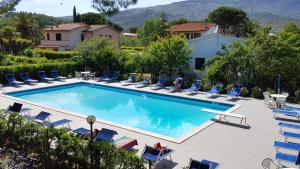 una piscina con sedie a sdraio e un resort di Hotel Lilly a Marina di Campo