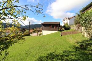 a grassy yard with a house in the background at Chalet de Grany, magnifique vue sur le lac de Gérardmer in Gérardmer