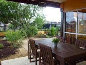 a wooden table and chairs on a patio at Kekemba Apartments Paramaribo in Paramaribo