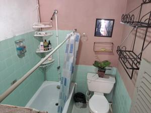 a bathroom with a toilet and a bath tub at Hostal Genoveva in San Salvador