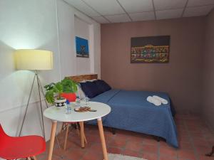 a small room with a bed and a table and a lamp at Hostal Genoveva in San Salvador