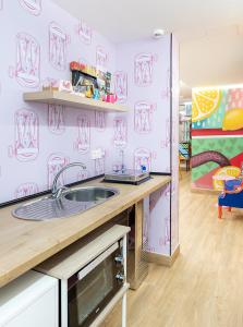 a kitchen with a sink and a pink wall at Lemon & Green GuestHome in Granada