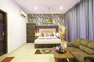 ニューデリーにあるHotel Kiara Grand - Near Mahipalpur Main Marketのベッドとソファのあるホテルの部屋