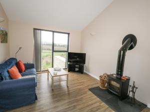 - un salon avec un canapé bleu et un poêle à bois dans l'établissement Frogwell, à Sherborne