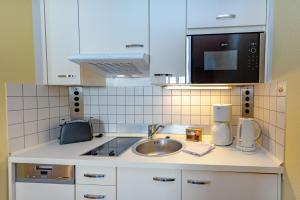 a kitchen with a sink and a microwave at Wohnpark Stadt Hamburg - Apt. 15 in Binz