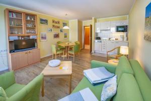a living room with a green couch and a kitchen at Wohnpark Stadt Hamburg - Apt. 15 in Binz +11 photos