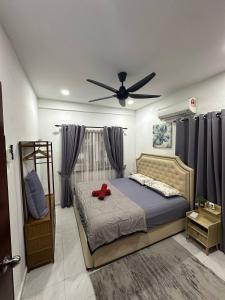 a bedroom with a bed and a ceiling fan at AliyaRoseMuslim Homestay in Ayer Keroh