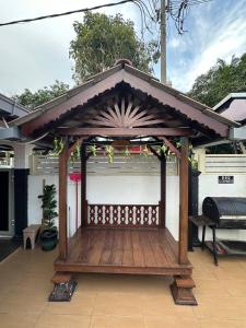 a wooden gazebo with a roof on a patio at AliyaRoseMuslim Homestay in Ayer Keroh