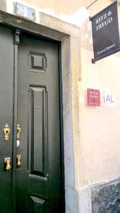 una puerta verde al lado de un edificio en Ritz & Freud Guest House, en Lisboa