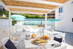 an outdoor patio with tables and chairs with food on it at Best Western Hotel Blumarea in Castelsardo