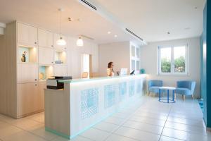 a woman standing at a counter in a room at Hotel Blumarea, BW Signature Collection in Castelsardo +152 photos