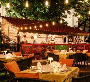 a restaurant with tables and chairs and lights at Novotel Mumbai Juhu Beach in Mumbai