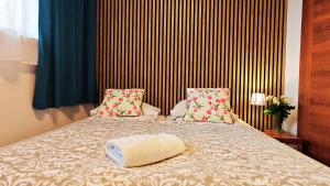 a bed with a white towel on top of it at Pod Wydmą in Unieście