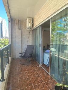 a balcony of a house with a chair and a bed at Quarto do junior in Belém