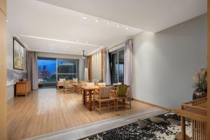 una sala de estar con una mesa y sillas en Ouchen International Administrative Mansion Himalaya Branch, Nanbin Road, Chongqing, en Nan'an