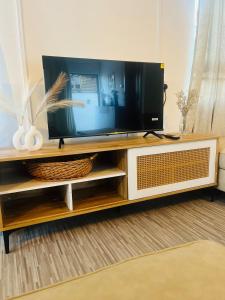 a flat screen tv on a wooden entertainment center at Auralis Villa in Flic-en-Flac