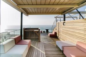 a balcony with couches and a view of the ocean at Hayarkon Apartment By the Sea in Tel Aviv