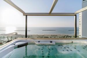 a hot tub with a view of the ocean at Hayarkon Apartment By the Sea in Tel Aviv
