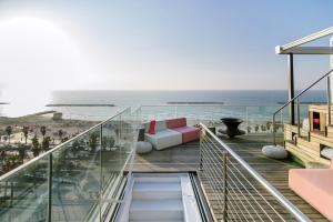 a balcony with a couch and a view of the ocean at Hayarkon Apartment By the Sea in Tel Aviv