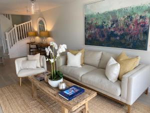 a living room with a couch and a table at No 1 The Hides Luxury House in North Norfolk in Titchwell +11 photos