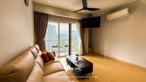 a living room with a couch and a large window at Windmill Upon Hills Premium Suites Genting Highland in Genting Highlands