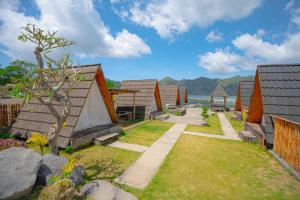 クブペンロカンにあるAnd Dita Glampingの家が並び、芝生がある裏庭