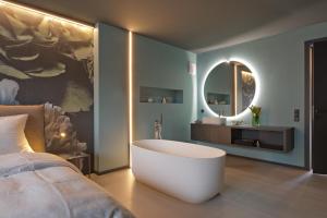 a bedroom with a tub and a bed and a mirror at Z-Apartment Parkgasse in Schladming