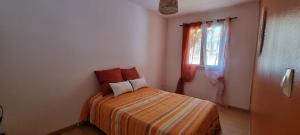 a small bedroom with a bed and a window at La Kaz Bellepierre in Saint-Denis