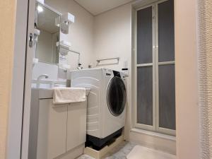 a bathroom with a washing machine and a sink at Casa de sol in Miyakojima +2 photos