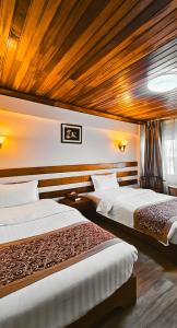 ナイロビにあるEastland Hotelのベッド2台 木製天井の客室内