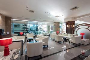 a waiting room with white chairs and tables at Elizabeth Hotel in Bangkok