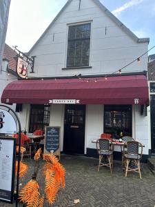 a restaurant with a table and chairs in front of a building at Tante Bed 44 B in Voorschoten