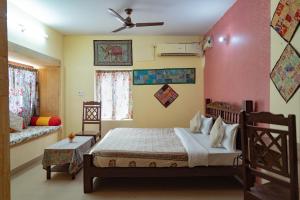 a bedroom with a bed and a couch and a window at Hotel Rumis Jaisalmer in Jaisalmer