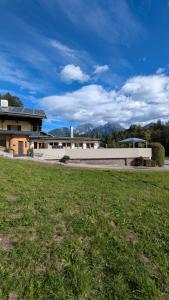 a large building with a grass field in front of it at Chalet Ferienwohnung Hochkalter in Schönau am Königssee