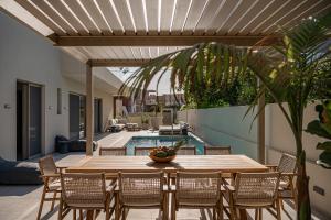 a patio with a table and chairs and a pool at Aurea Beach Villa in Kato Daratso