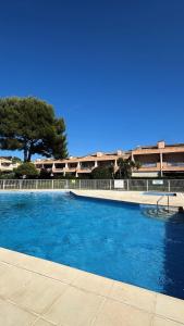 勒普拉代Appartement Hélène 200m plage, piscine et terrain de tennis的建筑物前的一个蓝色游泳池