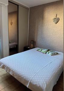 勒普拉代Appartement Hélène 200m plage, piscine et terrain de tennis的卧室里有一张大床，上面铺着蓝色毯子