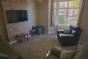 a living room with a couch and a tv at Okie Dokie - Charming seaside property in Sheringham